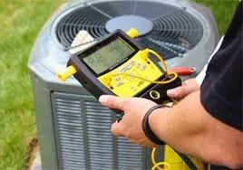 A person is holding a meter and an air conditioner
